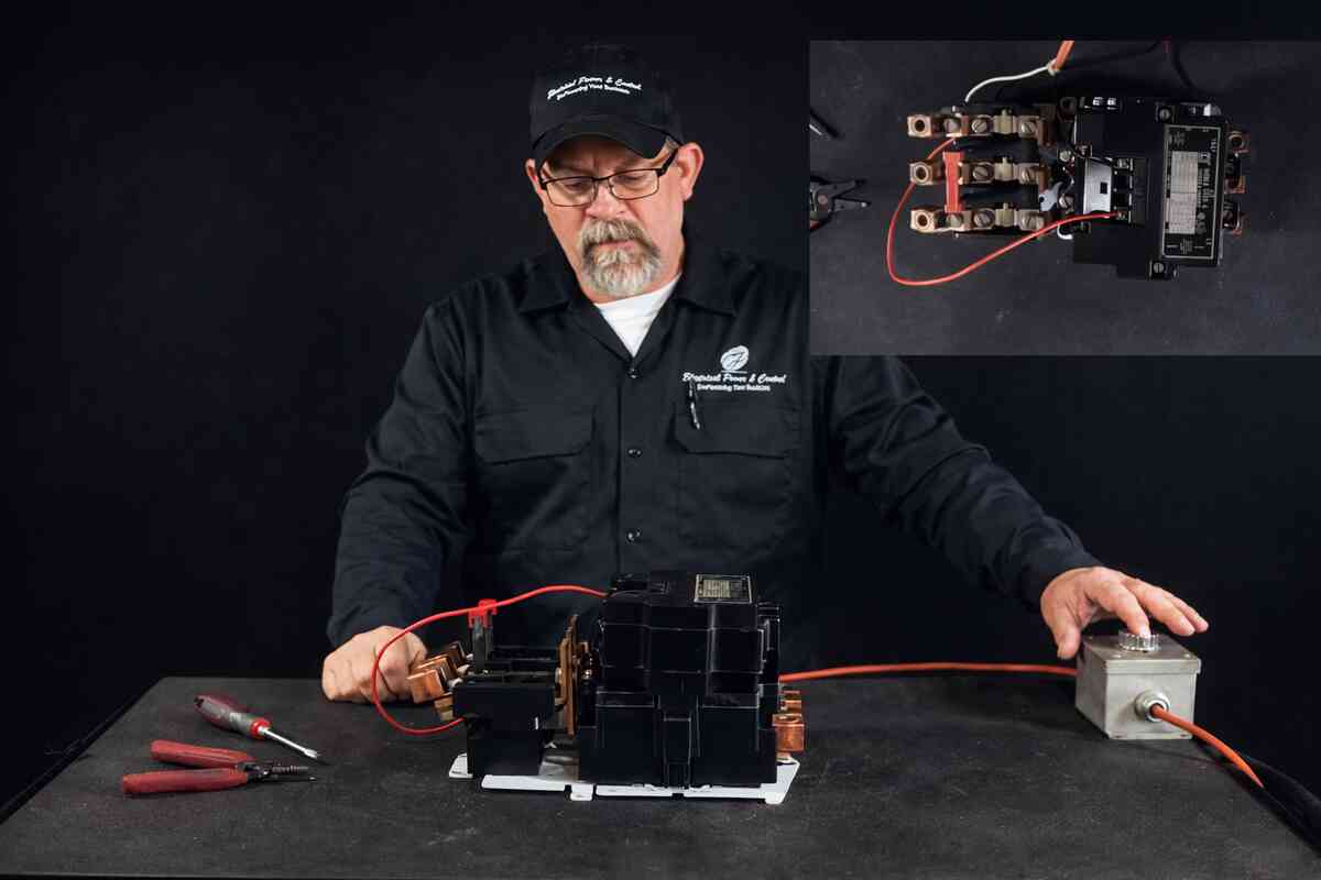 Maintenance engineer performing motor starter troubleshooting inside an electrical panel after repeated motor starter overload trips